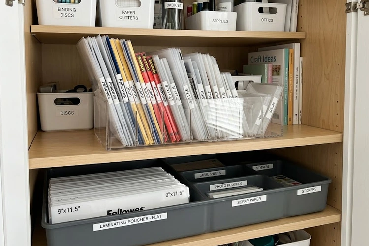 A person's hands carefully opening the paper path access panel of a sheet-fed document scanner to remove a crumpled jammed page, with a look of concentration and the scanner's error light visible.